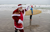 Surfing Santas take to the waves at the annual Christmas Eve event in Cocoa Beach