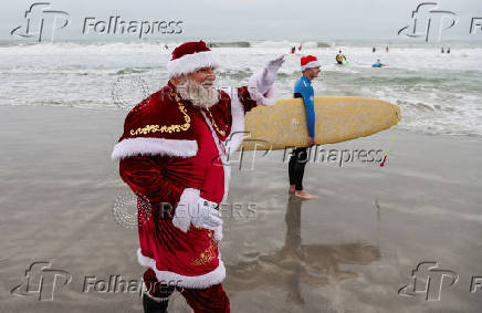 Surfing Santas take to the waves at the annual Christmas Eve event in Cocoa Beach