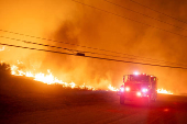 Firefighters and aircraft battle the Hughes Fire near Santa Clarita