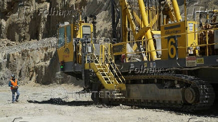 A worker walks near a drill rig in a pit at Anglo American's Los Bronces copper mine in Chile