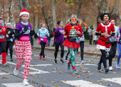 Runners wearing Santa Claus-themed outfits take part in the 