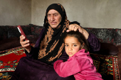 Tarfah Daaoud, a Kurdish Syrian woman, holds a mobile phone in Hasakah countryside