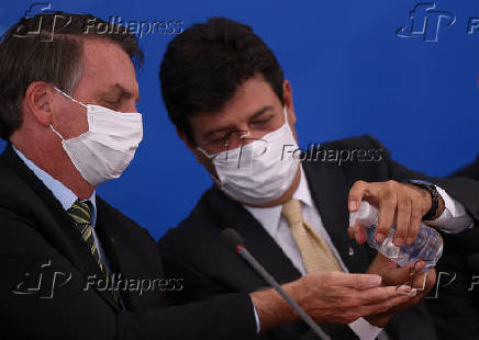 Ministro Luiz Henrique Mandetta (Sade) aplica lcool em gel na mo do presidente Bolsonaro