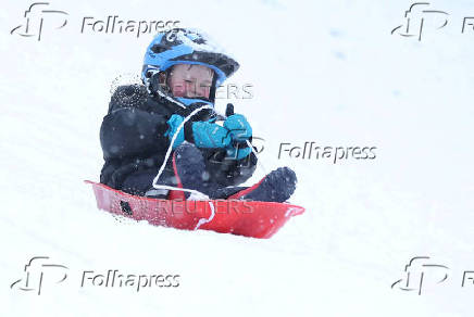 A boy is sledging in Aviemore, Scotland