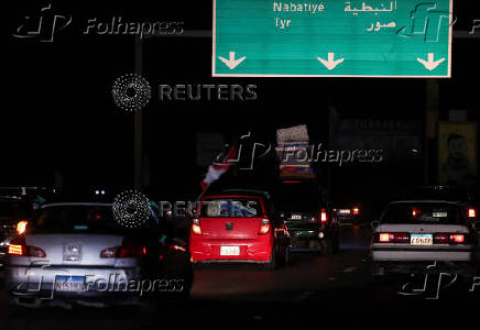 Vehicles drive south south from Zahrani, after a ceasefire between Israel and Iran-backed group Hezbollah took effect