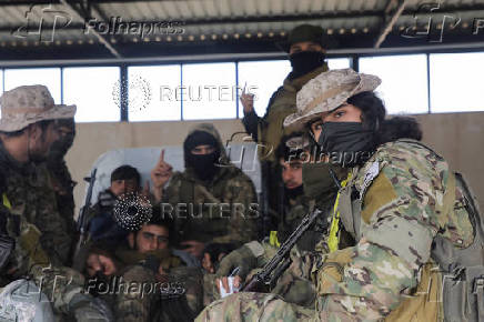 Rebel fighters sit together in Homs countryside