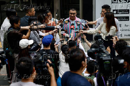 Transgender activist Henry Tse, who won the appeal to change the gender on his ID card, talks to the media outside the immigration office after receiving his new ID card in Hong Kong