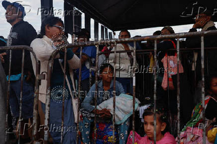 A Venezuelan, Glenda Vergara, 40, sits with her 3-year-old-daughter, as they queue to get documentation after leaving Venezuela, at the border, in Pacaraima