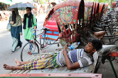 A man rests on a cart during a heatwave in Dhaka