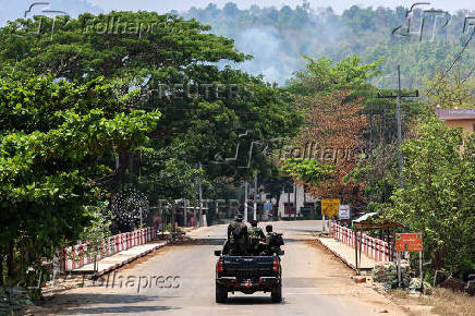 Soldiers from the Karen National Liberation Army (KNLA) patrol , next to an area destroyed by Myanmar's airstrike in Myawaddy, the Thailand-Myanmar border town under the control of a coalition of rebel forces led by the Karen National Union