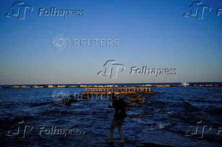 Angela from China enjoys a spring day in front of the Mediterranean Sea at the Barceloneta beach in Barcelona