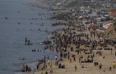 Internally displaced Palestinians spend their time at the beach west of Deir Al Balah