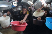 Palestinians gather to receive food cooked by a charity kitchen, amid the Israel-Hamas conflict, in the northern Gaza Strip