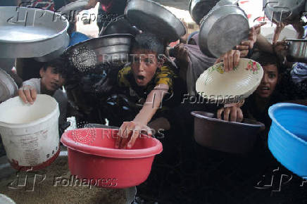 Palestinians gather to receive food cooked by a charity kitchen, amid the Israel-Hamas conflict, in the northern Gaza Strip