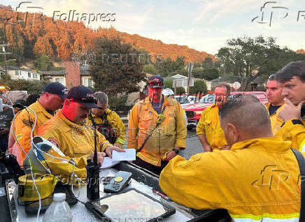 Firefighters work to stop a fire that damaged homes, in Oakland