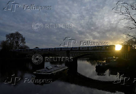 FILE PHOTO: A train crosses the river Thames in London