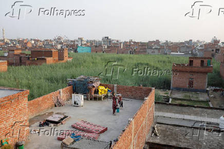 A woman puts her clothes to dry on a terrace in a neighbourhood in Loni town in the northern state of Uttar Pradesh