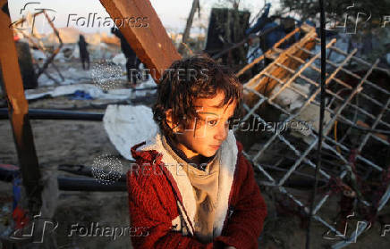 Palestinians inspect the damage at a tent camp sheltering displaced people, in Khan Younis