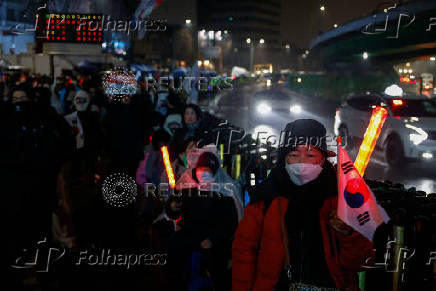 Pro-Yoon protesters are seen in the early light after rallying throughout the night in support of impeached South Korean President Yoon Suk Yeol near his official residence, in Seoul