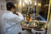 A woman poses for pictures at a Christmas theme park inside a shopping mall in Taipei