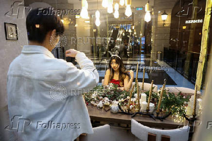 A woman poses for pictures at a Christmas theme park inside a shopping mall in Taipei