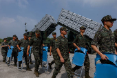 Members of the Taiwanese navy Hai Feng (Sea Blade) Group walk in front of Hsiung Feng III and II mobile missile launchers after Taiwanese President Lai Ching-te?s visit to the base in response to recent Chinese military drills, in Taoyuan