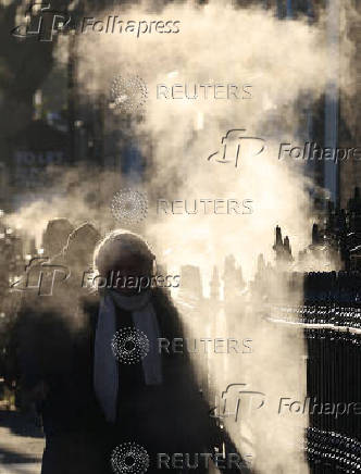 Commuters walk during the rush hour on a cold morning ahead of Ireland's general election, in Dublin