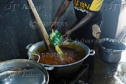 A cook prepares food inside the kitchen of a local restaurant in Lagos