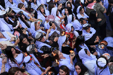 Iraqi Yazidi women light candles on the occasion of Red Wednesday, a ceremony to celebrate the Yazidi New Year at Lalish temple in Shekhan District in Duhok province