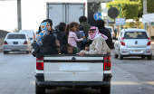 Internally displaced people ride on a pick up truck in Beirut