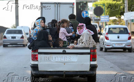 Internally displaced people ride on a pick up truck in Beirut