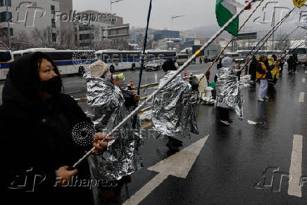 People take part in a protest against the impeached South Korean President Yoon Suk Yeol near his official residence on a snowy day in Seoul