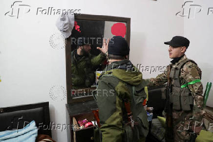 Fighters of Hayat Tahrir al-Sham (HTS) search for pro-Assad fighters and weapons in Homs