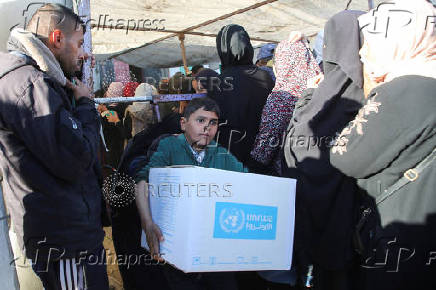 Palestinians receive aid following a ceasefire between Israel and Hamas, in Khan Younis in the southern Gaza Strip