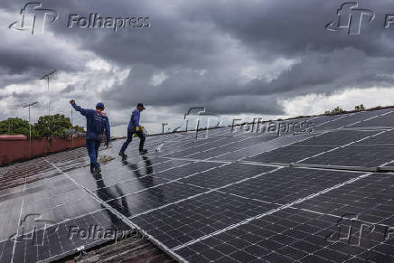 Operrios instalam painis solares no telhado do Sex Motel, em Boa Vista (RR) 