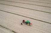A drone view shows a farmer near his tractor in his field in Vieillevigne