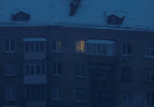 A cat is seen in an illuminated window of a residential building during power outages after Russian missile strike in Kyiv