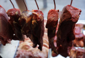 Pieces of meat hang at a butcher shop in Rio de Janeiro