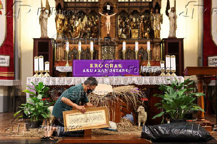 A man carries a frame to prepare for the Christmas mass at the Jakarta Cathedral in Jakarta