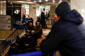 People take shelter inside a metro station during a Russian military strike, in Kyiv