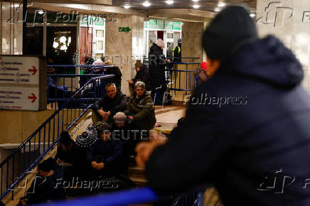 People take shelter inside a metro station during a Russian military strike, in Kyiv