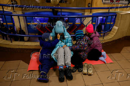 People take shelter inside a metro station during a Russian military strike, in Kyiv