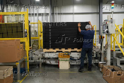 FILE PHOTO: Employees work on solar panels at the QCells solar manufacturing factory in Dalton
