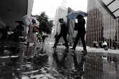 Pedestres se protegem do frio e da chuva na avenida Paulista, em So Paulo