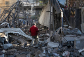 A man makes his way through the rubble of damaged buildings in the Chiyah district of Beirut's southern suburbs