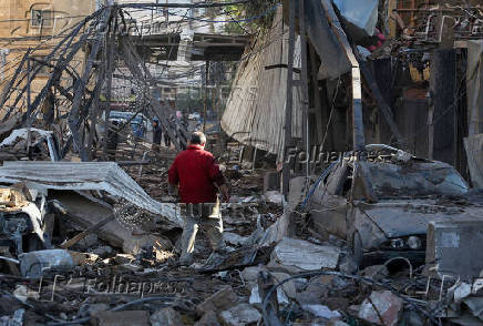 A man makes his way through the rubble of damaged buildings in the Chiyah district of Beirut's southern suburbs