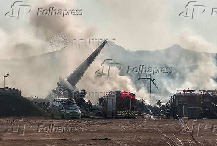 Firefighters carry out extinguishing operations on an aircraft which drove off runway at Muan International Airport in Muan