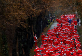 People dressed as Santa Claus run through the streets in Michendorf