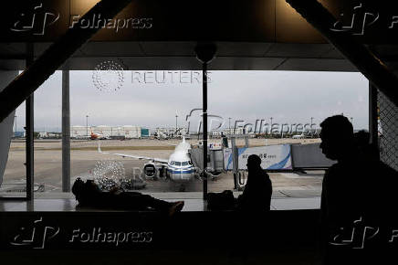 Passengers wait for their flights at the Beijing Capital International Airport, in Beijing