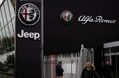 Car logos are displayed on the exterior of a car dealership